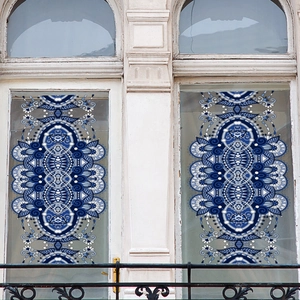 Detail of blue geometric mandala window film on white arched glass showing transparency