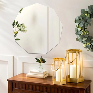 Close-up of a modern decagon frameless wall mirror on a minimalist white wall