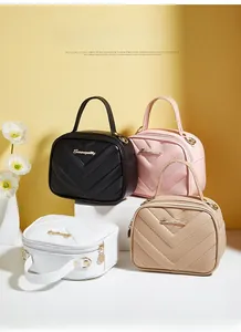 Detail shot of four small square bags in black, pink, white and beige with V-quilted pattern