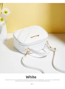 Detail of white PU leather bag with V-shaped quilting and golden logo hardware