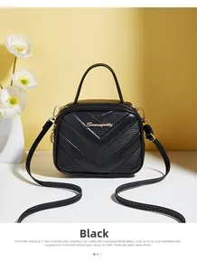 Detail of black quilted leather handbag with gold zipper and stylish V-shape stitching