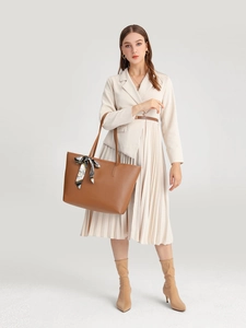 Detail der braunen Shopper Tasche mit stilvollem bedrucktem Seidenschal am Griff