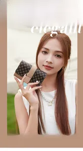 Detailed close-up of brown monogram short wallet held by a model in outdoor setting