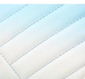 Detail shot of quilted blue gradient leather with diagonal stitching on crossbody bag