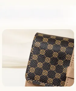 Detail of dark lychee grain leather wallet with gold clover print and beige piping