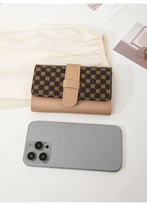 Close-up of bicolor women's short wallet with clover pattern and pebbled leather texture