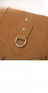 Détail du sac à main vintage en daim avec franges marron et rivets dorés brillants
