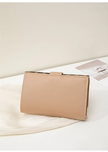 Close-up of beige leather wallet with classic monogram trim and snap button closure