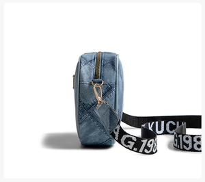 Detail view of denim crossbody bag with quilted texture and gold metal hardware