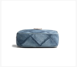 Detailed bottom view of light blue denim crossbody bag with quilted diamond pattern
