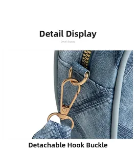Detail view of denim handbag featuring a detachable metal hook and gold zipper closure