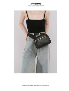 Close-up of litchi texture black leather waist bag featuring double gold metal zippers