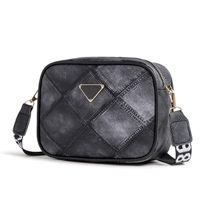 Denim patchwork crossbody bag with quilted texture and wide strap on white background