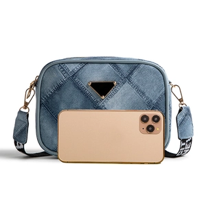Quilted denim crossbody bag with geometric patchwork and adjustable lettered strap