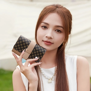 Chic women's tri-fold wallet in brown patchwork leather held by a model outdoors