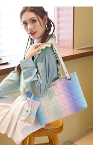 Detail of gradient heart quilted tote bag and matching coin purse on a model