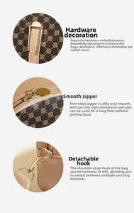 Detailed macro of gold-tone hardware rings and smooth zipper on brown printed bag