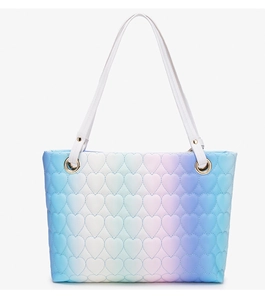 Detail of heart quilting on gradient tote bag with metal grommets and faux leather straps