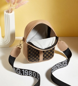 Overhead view of compact leather crossbody bag interior with stylish printed shoulder strap