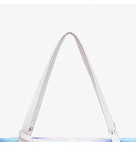 Detail of gradient tote bag handle with golden studs and quilted leather texture
