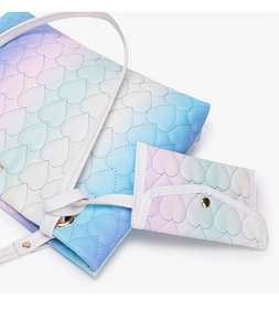 Detail of heart-quilted gradient tote bag and matching coin purse with golden hardware
