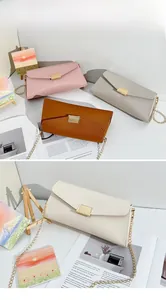 Detail view of stylish envelope crossbody bags in four colors with gold chain straps