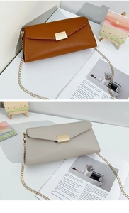 Detail of lychee pattern leather texture and gold metal buckle on envelope chain bags