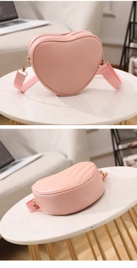 Detail of pink heart-shaped crossbody bag with V-quilt pattern and gold metal hardware