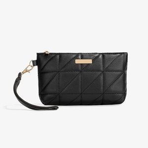 Detail of black quilted wristlet clutch with gold hardware and smooth faux leather texture