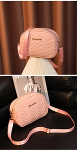 Détail du sac bandoulière rose matelassé avec logo doré et large bandoulière