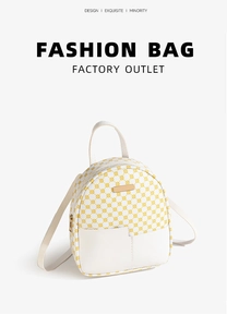 Dettaglio mini zaino a pois gialli con tasca anteriore bianca e placca logo in metallo