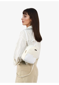 Vista laterale di un mini zaino da donna a pois gialli con inserti in pelle bianca