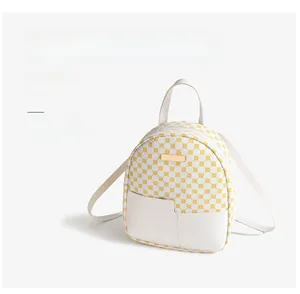 Dettaglio del mini zaino con motivo geometrico giallo e tasca frontale a fessura