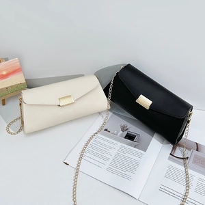 Minimalist envelope crossbody bag with gold chain strap in cream and black leather