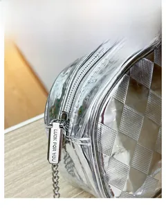 Détail de la fermeture éclair en métal et gravure sur le sac argenté à motif damier