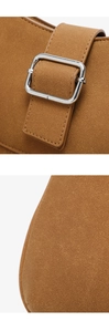 Detail of tan suede shoulder bag showing silver metal buckle and premium stitching texture