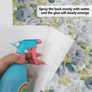 Detail of water spray application on the back of floral peel and stick wallpaper