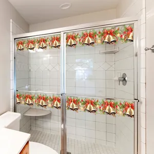 Christmas bell glass stickers with red bows and pine branches on a glass shower door