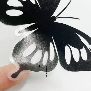 Close-up of glittery butterfly wall sticker showing adhesive backing and removable texture