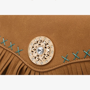 Dettaglio borsa a tracolla in pelle scamosciata marrone con fibbia boho e nappe