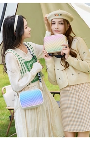 Detail of colorful V-quilted camera bags with wide branded straps in outdoor setting