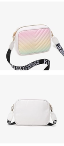 Detail of white camera bag with gradient V-quilted embroidery and branded woven strap