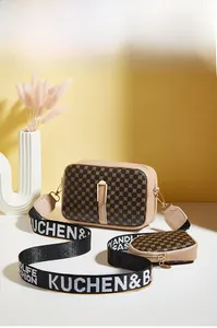 Detail of a chic 2-piece camera bag set with patterned canvas and wide jacquard strap