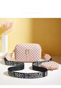 Close-up of pink camera bag set with geometric print and wide logo fabric strap