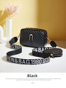 Detail of black printed camera bag with wide lettered strap and round coin purse