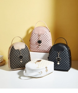 Detail of four colorful printed mini backpacks with metal cat charms on geometric stands