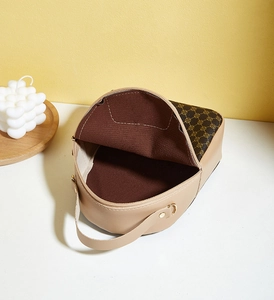 Detail view of mini crossbody bag showing brown floral pattern flap and single compartment