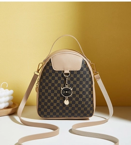 Detail of monogram leather mini backpack with cute metal cat charm and adjustable strap