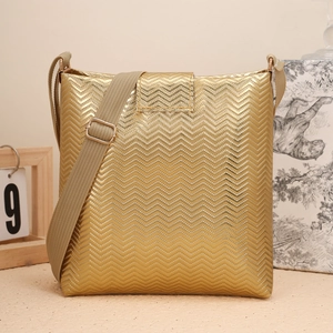 Détail du sac seau doré avec gaufrage en vagues et large bandoulière en tissu kaki