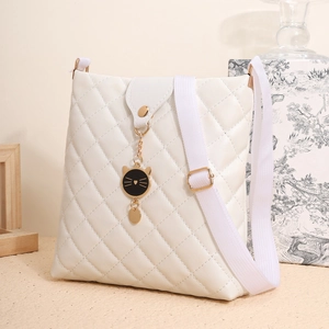 Détail du sac bandoulière blanc matelassé avec pendentif chat doré et sangle réglable